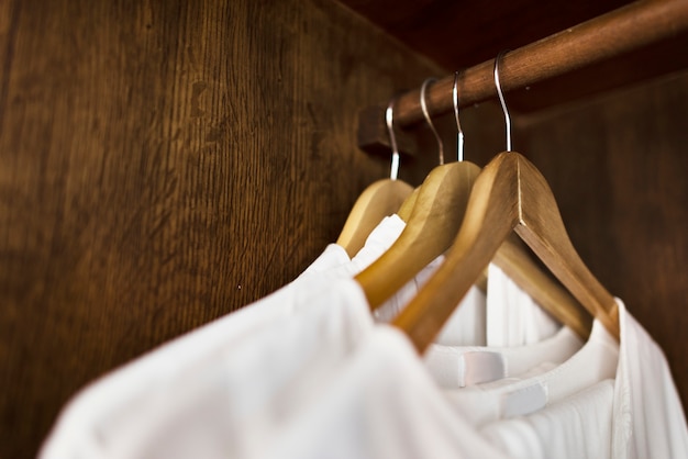 White clothes hanging in a wardrobe