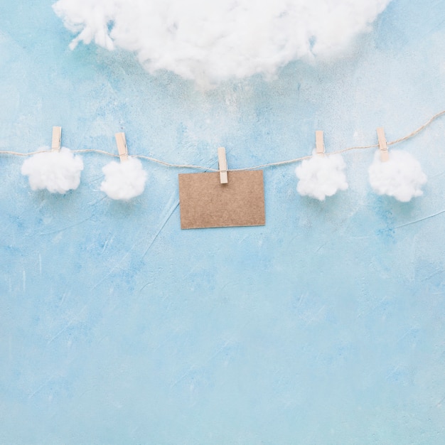 Free photo white clouds and brown card hang on a string with clothespins