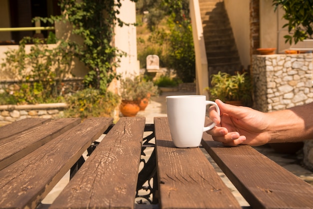 Free photo white coffee cup on table with outdoor setting