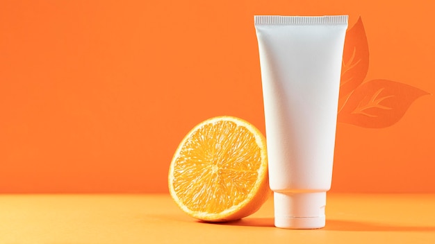 Free photo white cosmetic container with orange