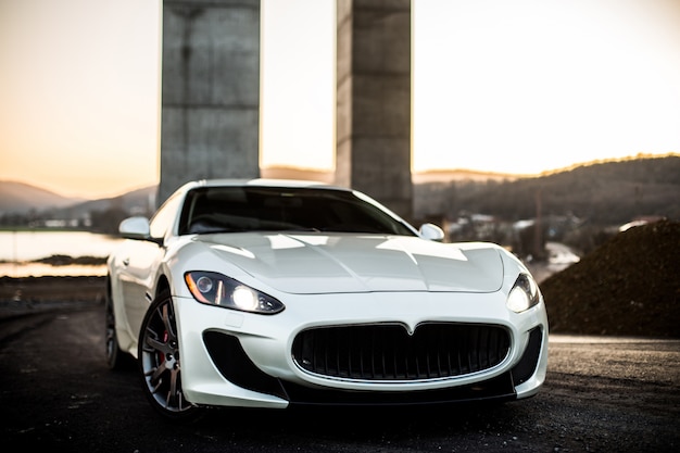 White coupe sport car standing on the road, front view.