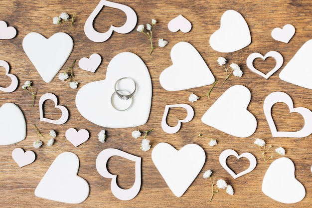 Free Photo white cut out heart shapes with baby's-breath flowers on wooden desk