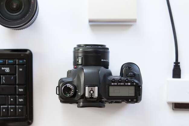 White desk with a professional camera and accessoires on it