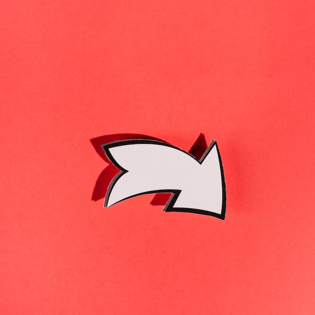 Free photo white directional arrow on red background