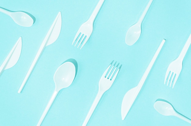 Free photo white disposable cutlery composition on turquoise background