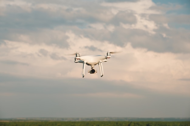 Free Photo white drone hovering in a bright blue sky