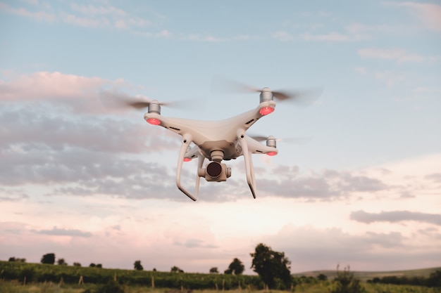 White drone hovering in a bright blue sky