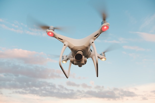 Free photo white drone hovering in a bright blue sky