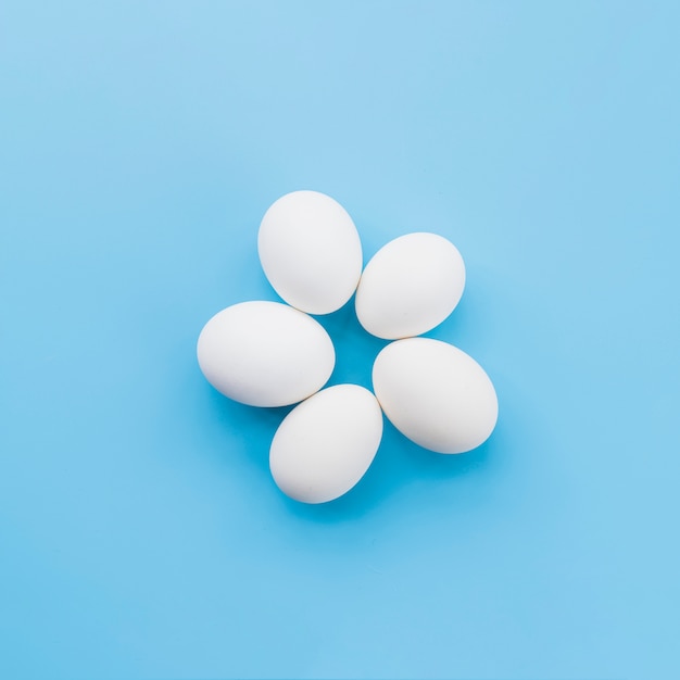 Free photo white eggs on blue background