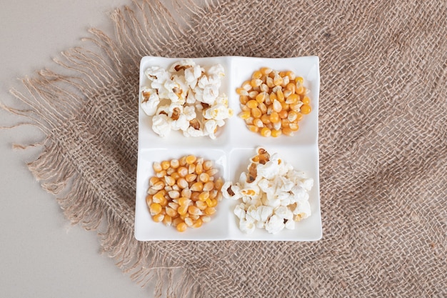 White fluffy popcorns in a ceramic cup on concrete.