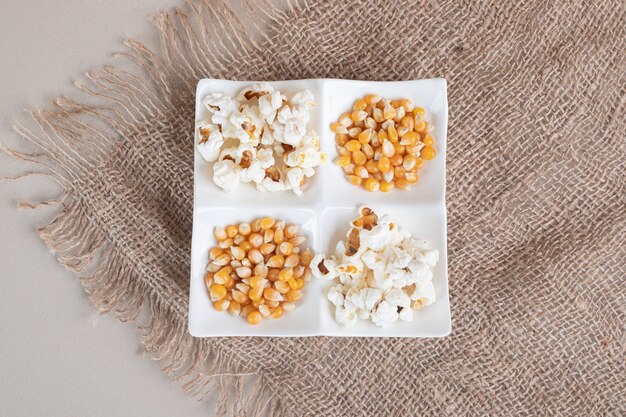 White fluffy popcorns in a ceramic cup on concrete.