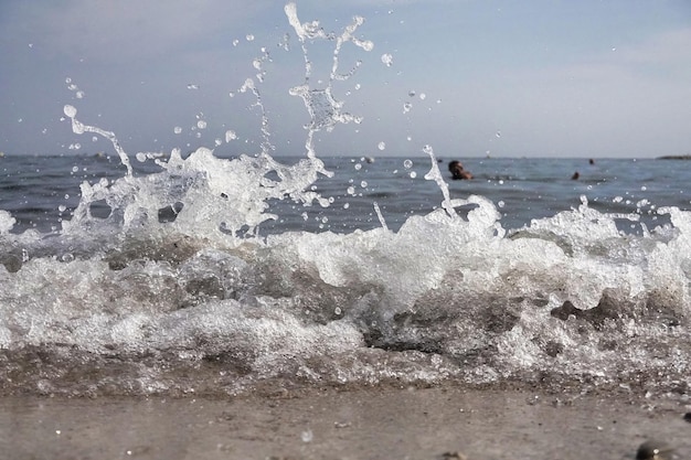 Free photo white foam and sea water drop splashes slow motion with sand and blue water