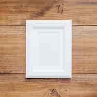 Free photo white frame on a vintage wooden background