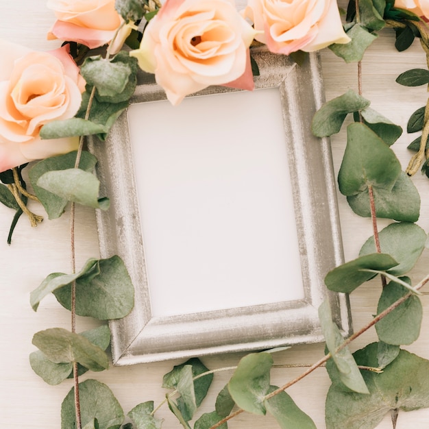 Free photo white frame with flowers and leaves