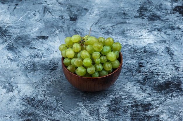 Free photo white grapes in a bowl close-up on a dark blue marble background