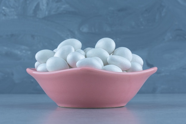 Free Photo white gums in the bowl, on the marble table. 