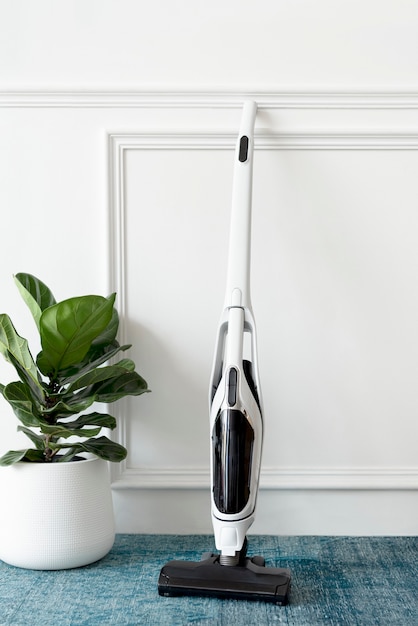 Free photo white handheld vacuum cleaner leaning against a wall