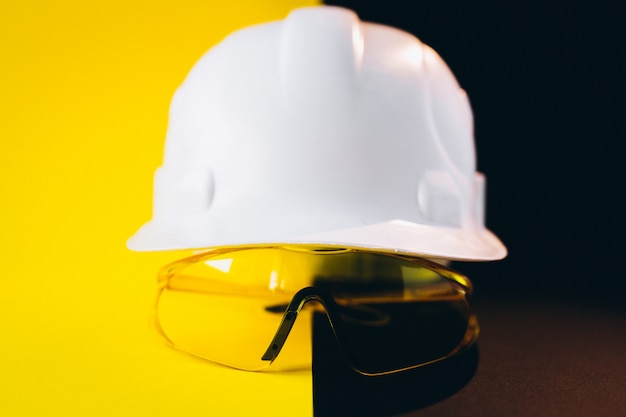 Free photo white hard hat with protection eyeglasses isolated