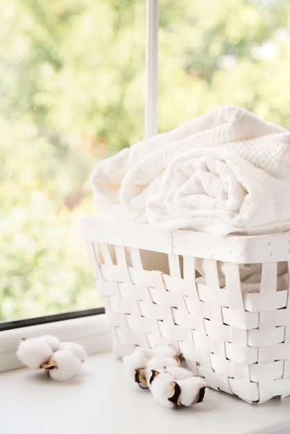 Free photo white laundry basket next to a window