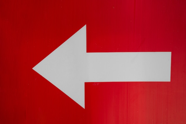 Free photo white left arrow on red background