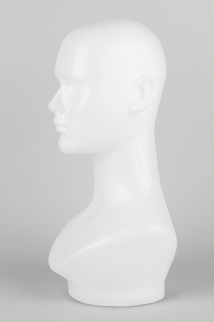 Free photo white mannequin head in profile on a gray background