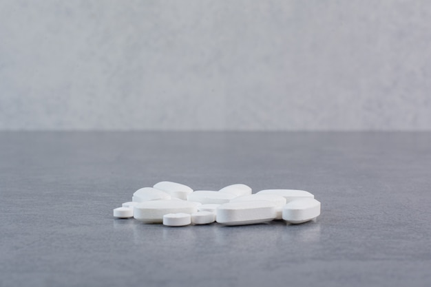 Free Photo white medical pills on marble table.