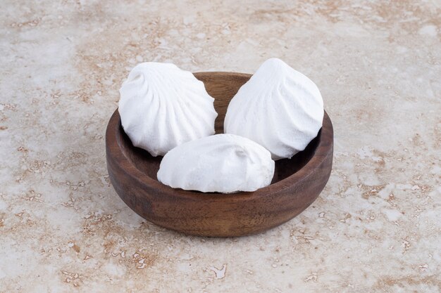 White meringue in a bowl, on the marble table. 