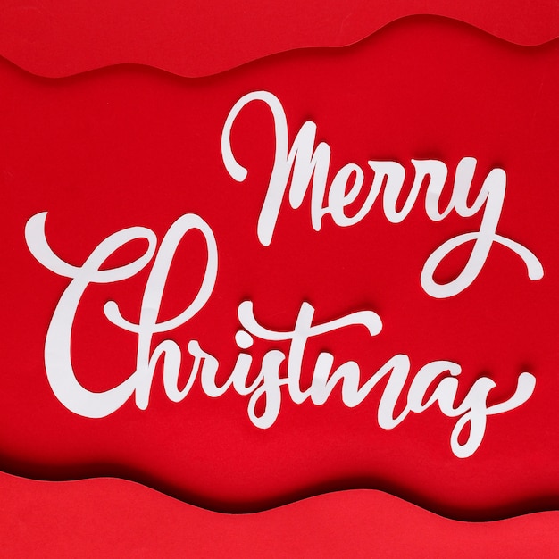 White merry christmas lettering on red paper with layers