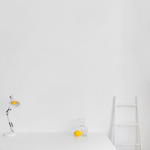 White minimalistic workspace with ladder and lemon