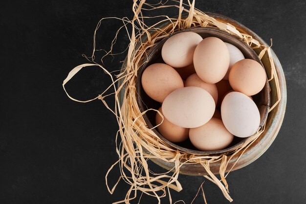 White organic eggs in a metallic cup, top view. 