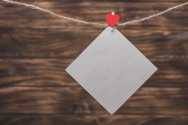 Free Photo white paper hanging from a rope with a clip with a heart