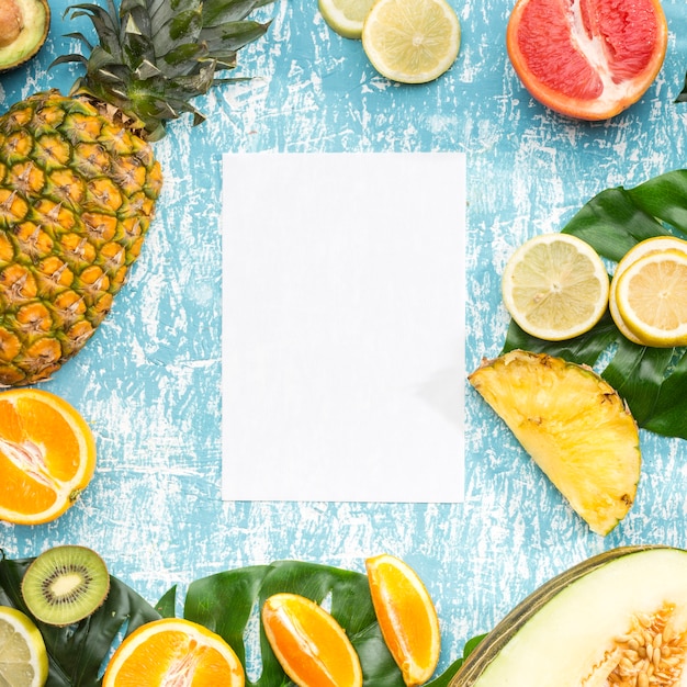 Free photo white paper surrounded by exotic fruits