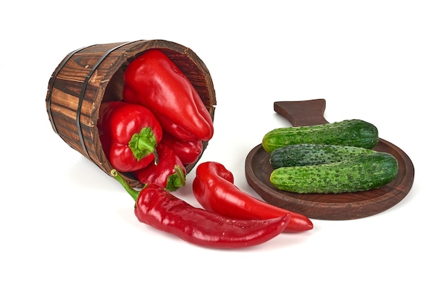 White pickles on a wooden platter and peppers out of a bucket.