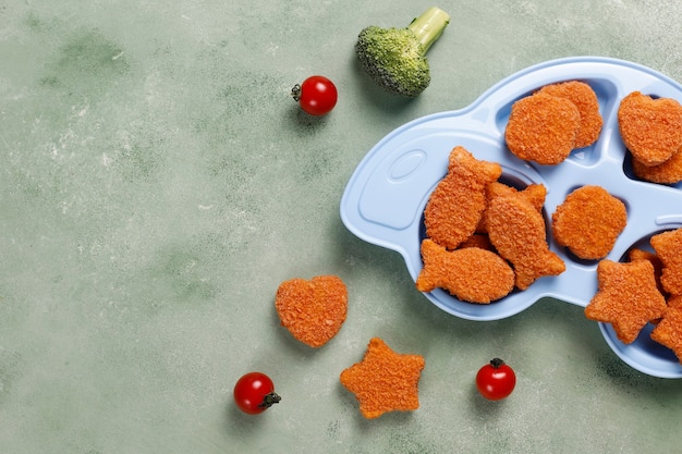 White plate of fish nuggets placed on stone table