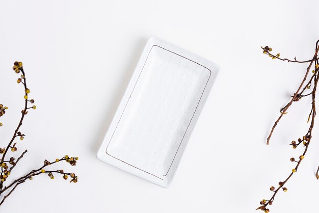 White plate in flat lay style with dried flowers