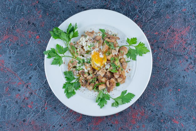 A white plate of fried egg with herbs . 