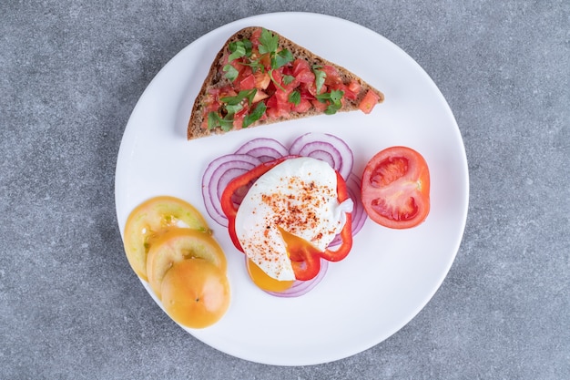 A white plate full of sliced vegetables and boiled egg. High quality photo