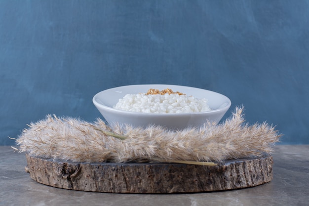 Free Photo a white plate of healthy oatmeal porridge on a wooden piece . 