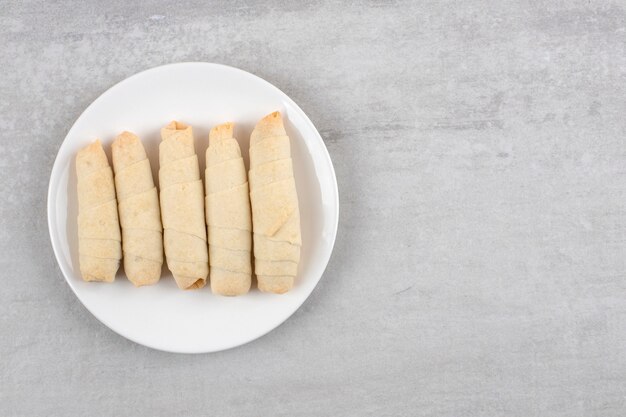 White plate of homemade sweet mutaki on stone table. 