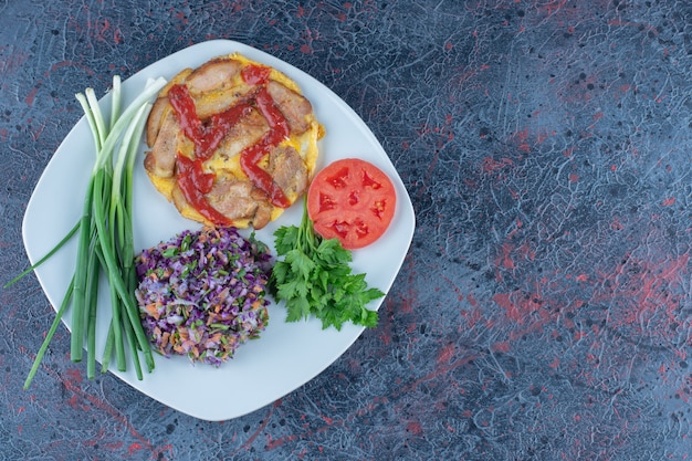 A white plate of omelet with herbs and green onions .