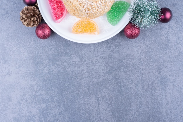 A white plate with cookie and sugary jelly candies