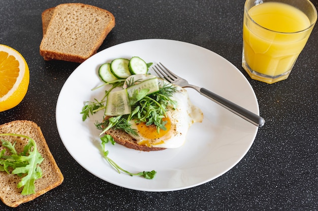 White plate with fried eggs and orange juice