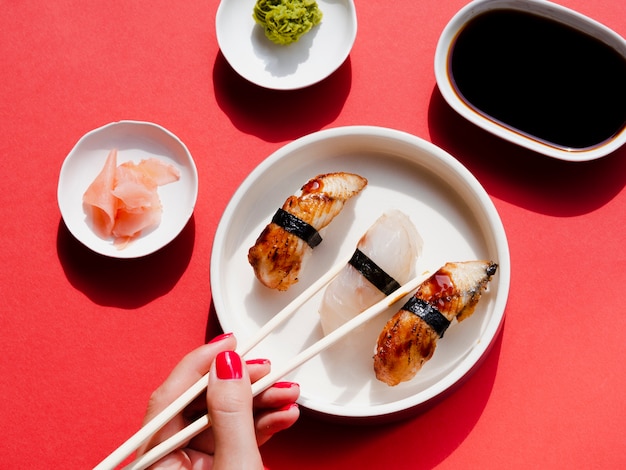 White plates with sushi and wasabi on a red background