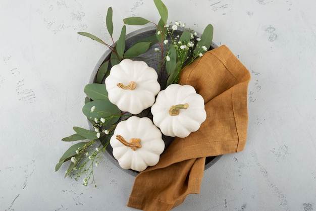 Free Photo white pumpkins, cloth and leaves top view