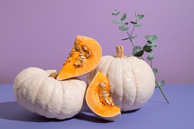 Free photo white pumpkins with purple background