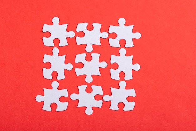 Free photo white puzzle pieces and red background