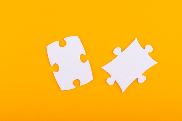 Free photo white puzzle pieces with orange background