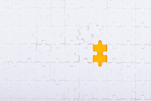 Free photo white puzzle pieces and yellow background top view