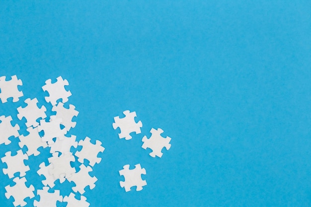 Free Photo white puzzles on a blue background flat lay