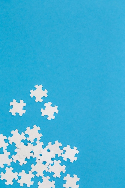 Free Photo white puzzles on a blue background flat lay